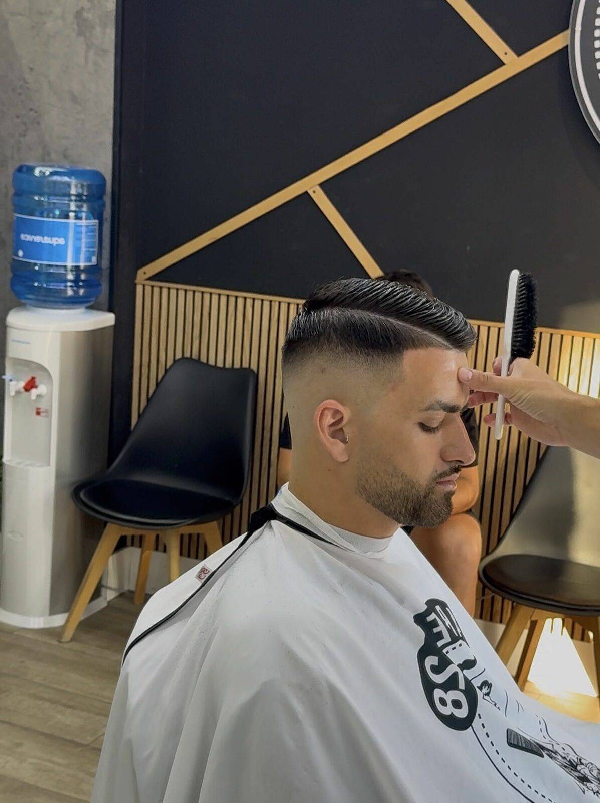 Barbero de Barber28 trabajando un corte con peine y tijera