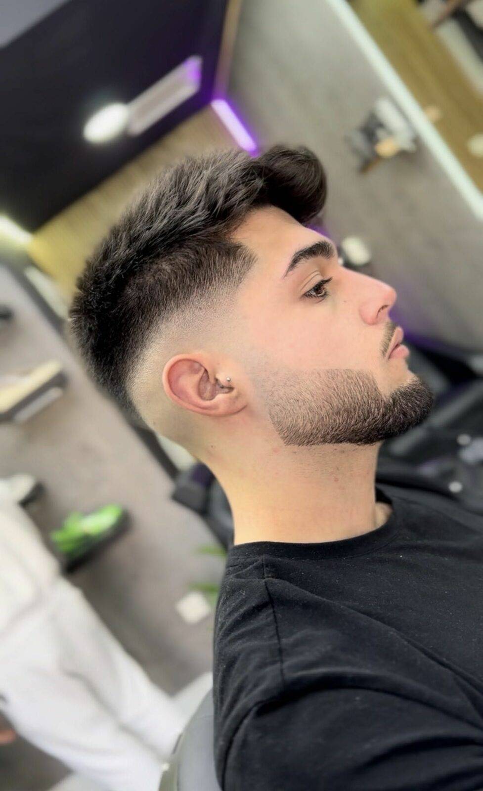 Corte con degradado medio y barba perfilada, vista de perfil
