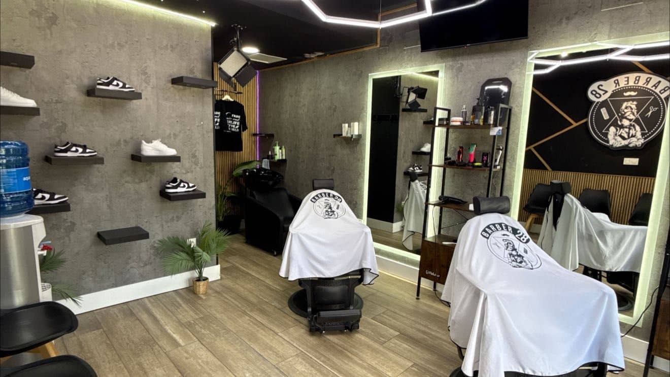 Interior del local de Granada Centro: dos sillones con capas de la casa frente a los espejos y zapatillas expuestas en la pared